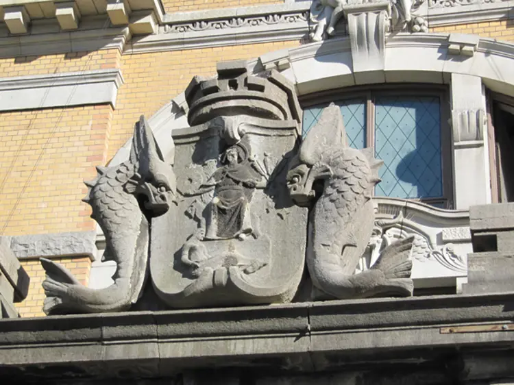 Forvitring av kalkstein. Bildet viser en detalj fra Nasjonaltheateret. Kalksteinen er kraftig angrepet av forvitring, deler av Sankt Halvard figuren er nesten etset bort, og den har fått en tykk, svart skorpe av nedbrytningsprodukter. Foto: Tom Andersen