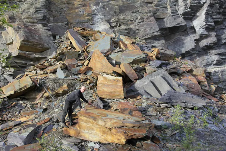 Selv Odd Arne Rudi blir liten i det store bruddet. 200 ansatte var på det meste involvert i produksjon og eksport av skifer i Valdres. Foto: Bygg og Bevar