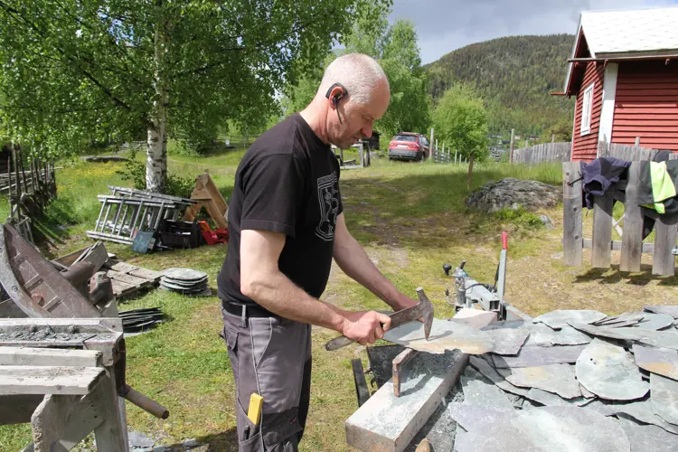 Leirskiferen er ikke så sprø som kvartskiferen. Man kan derfor lage spikerhull med piggen på skiferhammeren og skiferen kan formes med kniven på hammerens skaft. Foto: Bygg og Bevar