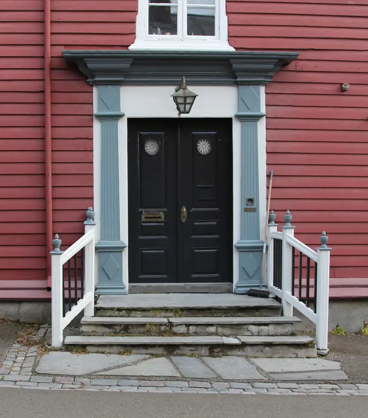 Mørk ultramarin-blå dør med lysere ultramarin detaljer mot hvitt. Rød kledning. Røros. Foto: Christel Wigen Grøndahl, Bygg og Bevar