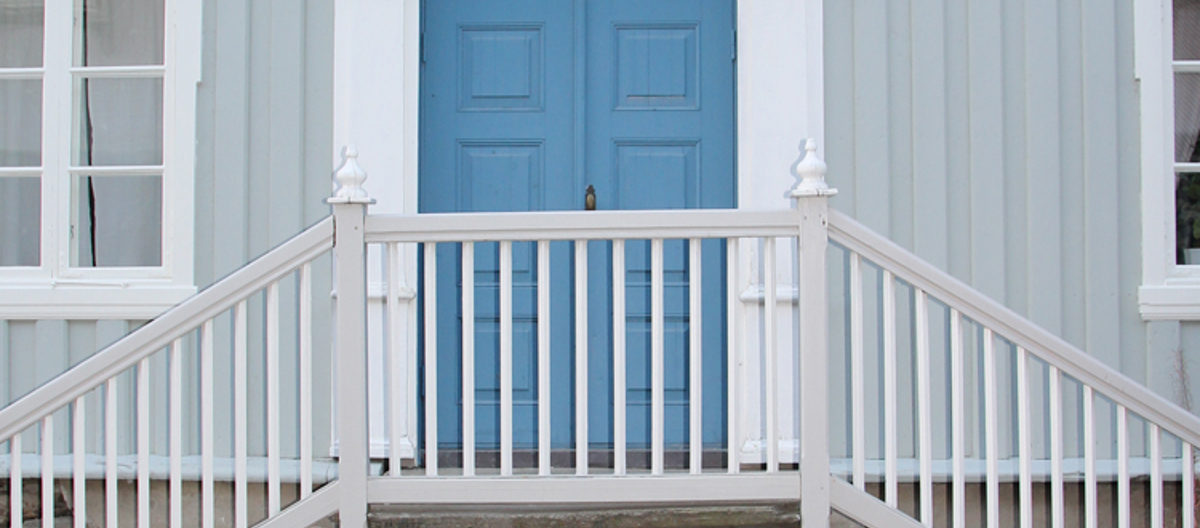 Dør i klar ultramarin, hvit omramming og lys ultramarin vegg. Foto: Christel Wigen Grøndahl, Bygg og Bevar