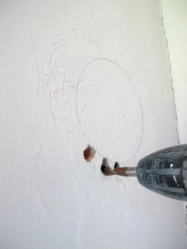 2 Jeg hadde ikke hullsag i rett dimensjon, så jeg brukte steinbor rundt åpningen. Siden dunket jeg inn bitene. Foto: Norske Hjem