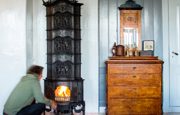 En flott, gammel ovn er som et smykke i stua. Foto: Norske Hjem