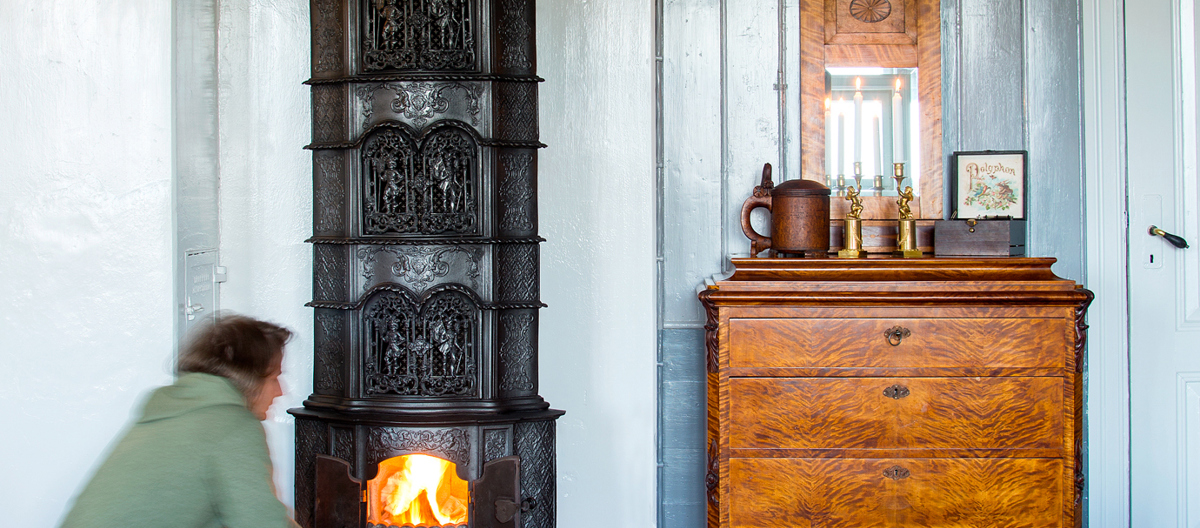 En flott, gammel ovn er som et smykke i stua. Foto: Norske Hjem
