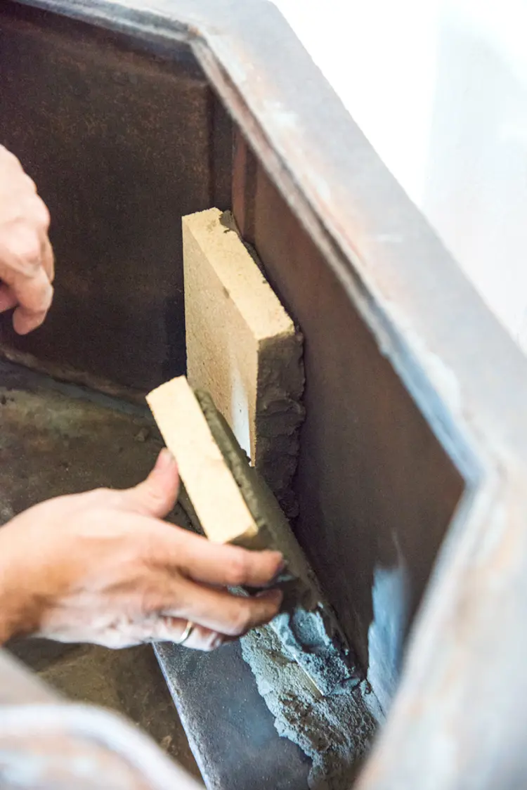 11 Steinene plasseres side om side, med tynn fuge, inne i brennkammeret. Foto: Norske Hjem