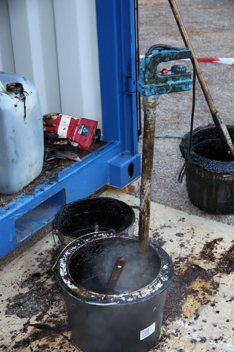 Oppfinnsomt! For å holde tjæra varm kom de på å bruke en varmekolbe som vanligvis benyttes for å varme melk til kalvene. Temperaturen blir mye lettere å kontrollere. Foto: Christel Wigen Grøndahl