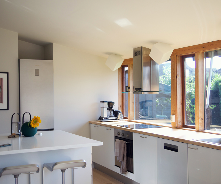 Kjøkkenet er bevart fra slik det var da Louise sin mor bodde her, og er fortsatt lyst og funksjonelt med åpen planløsning. En barløsning med barkrakker gir en uformell spiseplass. 