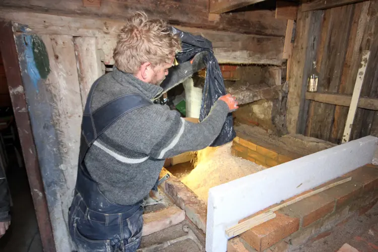 Fyller med sagflis. Foto: Terje Granås, Bygningsvernsenteret i Aust-Agder
