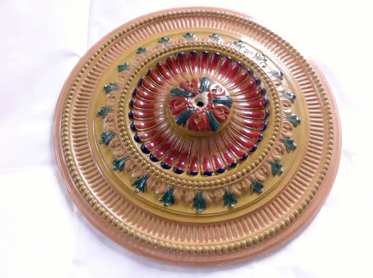 Gipsrosett malt i originale farger. Man gikk heller ikke av veien for litt gull på slutten av 1800-tallet. Hullet i midten er til lampekroken. Foto: Einar Nilsson, EinArt