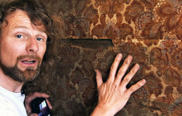 Einar har funnet et gammelt tapet inni veggen.