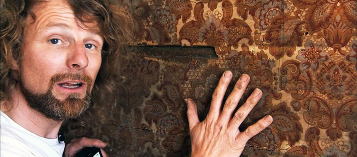 Einar har funnet et gammelt tapet inni veggen.