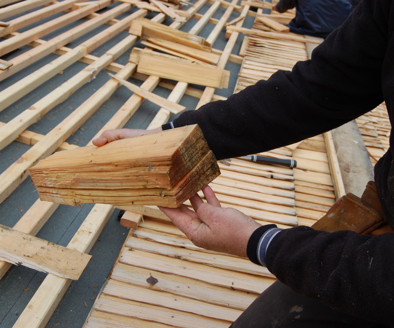 Taket var lagt med innstikksida ned. Her vurder håndverkeren stikkeretning og forbereder spikring. Foto: Kulturminnefondet