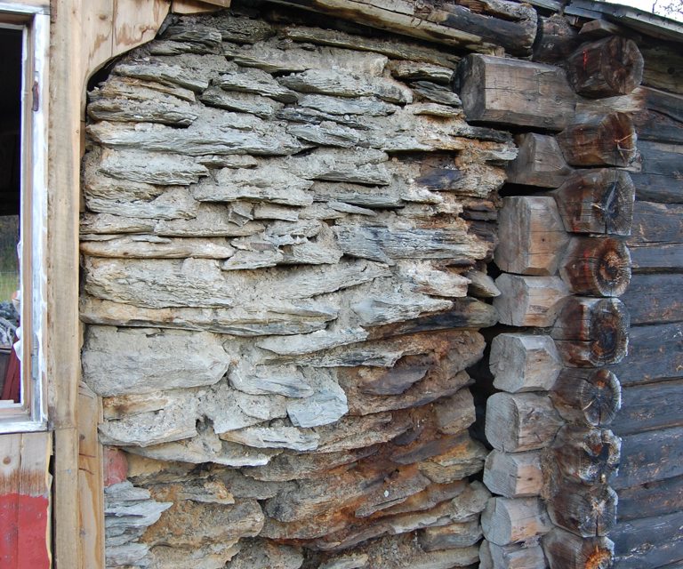 Her vises at fundamentstein er brukket og at bakveggen i grua er forvitret. Foto: Kulturminnefondet