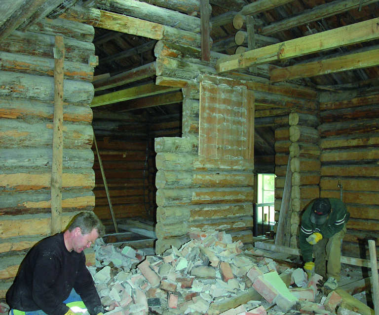 Teglsteinspipa tas ned, all egnet stein renses og brukes om igjen. Her ser vi Jon Erling Mustorp i sving med hammeren en dugnadsdag. Foto: Norske Hjem