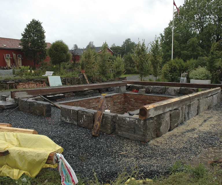 Kjelleren er ferdig og alle grunnmurssteinene er på plass. De første bunnsvillene er i ferd med å tilpasses den nye grunnmuren. Vær oppmerksom på at gamle grunnmurer ikke nødvendigvis er i vater og at du må ta hensyn til dette under gjenoppføringen. Vær nøye med oppmålingen! Foto: Norske Hjem