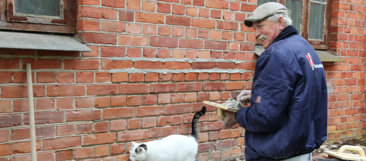 Kursholder og murmester Thomas Watson fra Watson Facaderenovering i Danmark. Katta på gården ville være å sjekke hva som skjedde! Foto: Christel Wigen Grøndahl