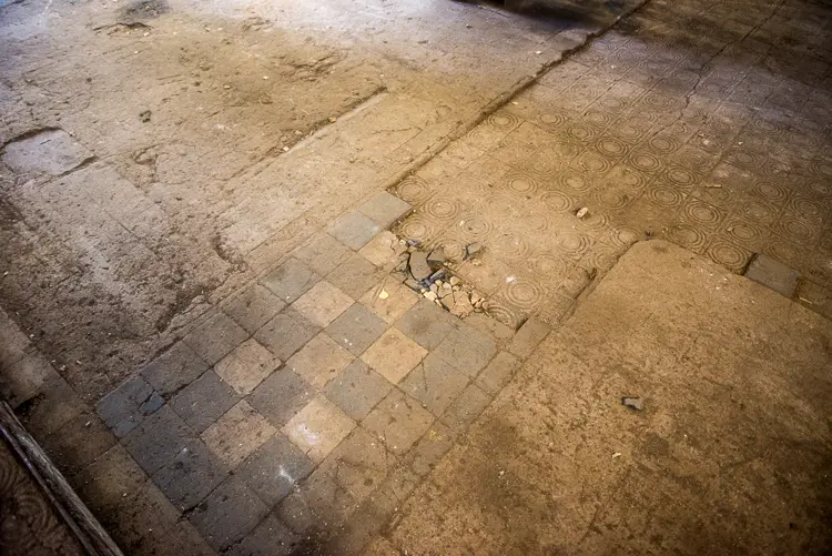 Gulvet i turbinhallen er en utfordring. Mange av flisene er ødelagte eller fjernet i årenes løp. Karen og Lars ønsker seg gulvvarme, men lar det seg forene med en bevaring av gulvet? Foto: Sjur Harby