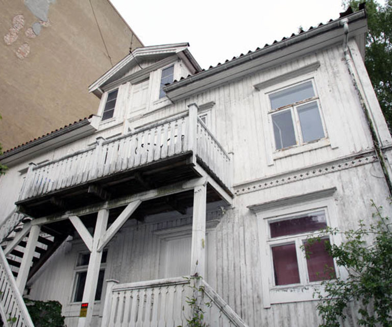 Trappen er bygget i senere tid og medførte råteskader fordi fallet på trappereposet ledet regnvannet mot ytterveggen. Foto: Bygg og Bevar