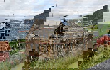 Takkonstruksjonen er bygget opp igjen, bindingsverket i gavlen er fjernet og kledningen er fjernet. Taket er vindtettet. Foto: Solvorn Laft og Bygg