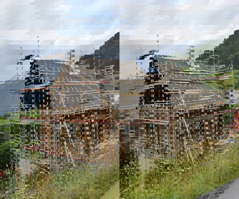 Takkonstruksjonen er bygget opp igjen, bindingsverket i gavlen er fjernet og kledningen er fjernet. Taket er vindtettet. Foto: Solvorn Laft og Bygg