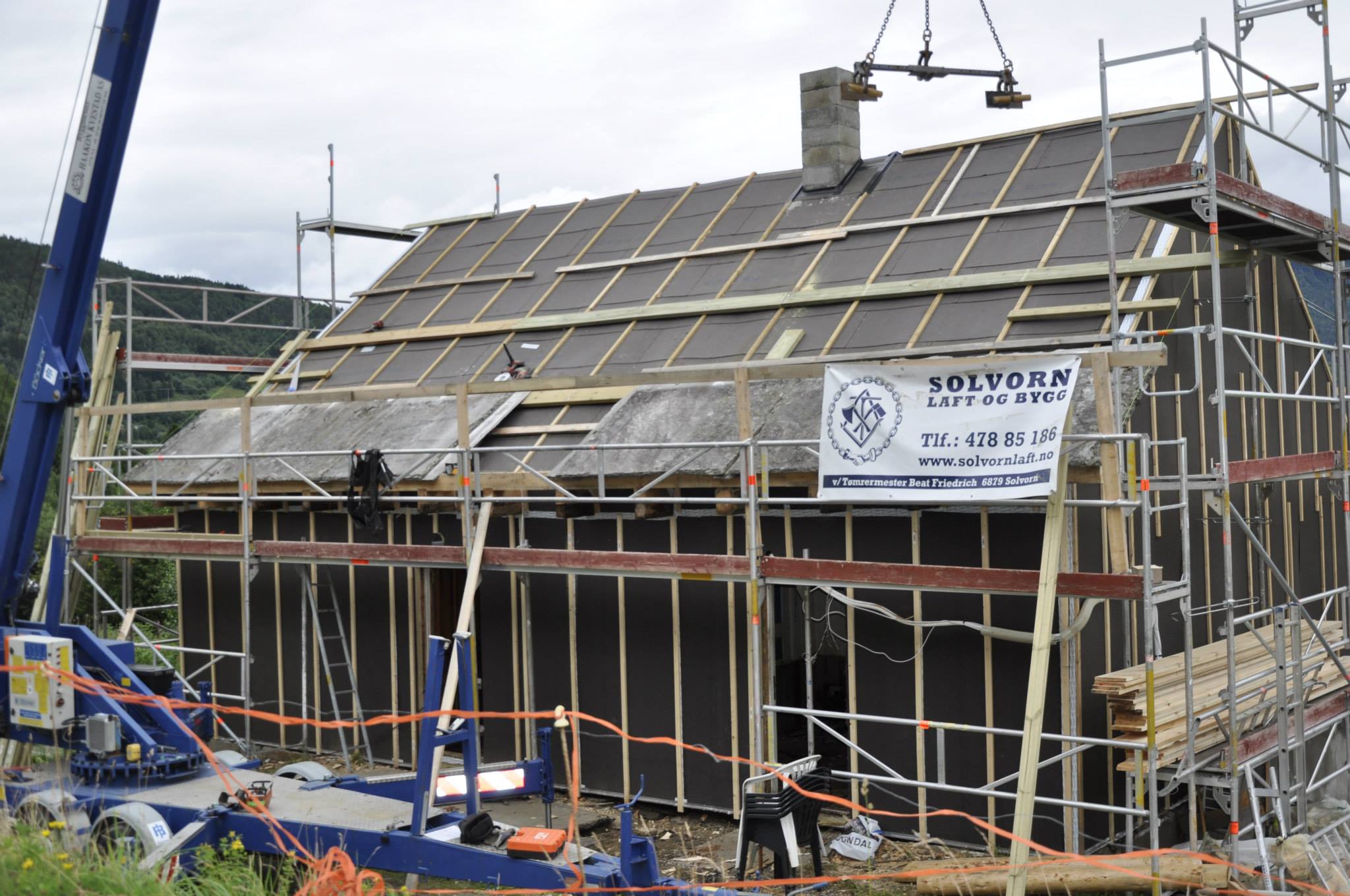 Huset er vindtettet og de gamle skiferhellene på taket løftes tilbake på plass. Foto: Solvorn Laft og Bygg
