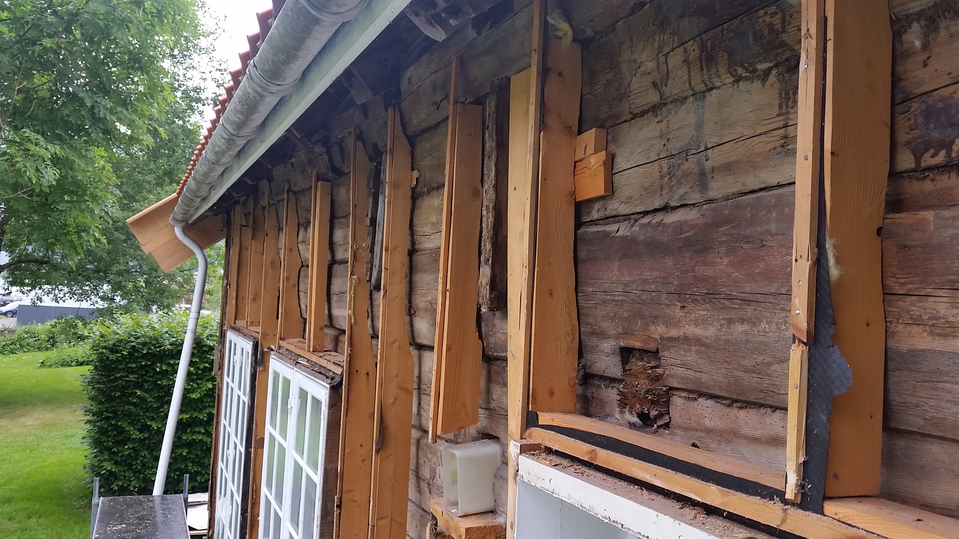 Her har man montert et stenderverk på lafteveggen. Asfaltplater monteres inntrukket og stenderne lektes ut for å få tilstrekkelig med lufting. Foto: Ove Losnegård.