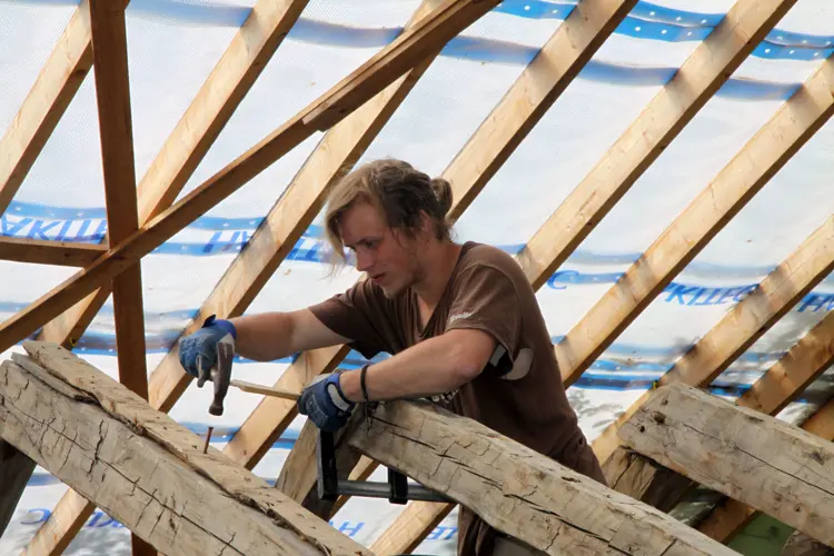 Henrik Jenssen fester taksperrene i mønet med nye trenagler. Foto: Christel Wigen Grøndahl, Bygg og Bevar