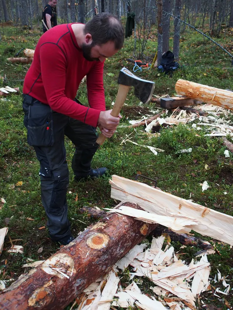 Etter at stokken er delt må den hugges ned til to glatte bord. Foto: Åge Emil Bergquist