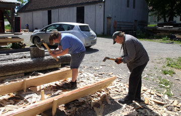 Peter Brennvik og Roald Renmælmo. Student og lærer hugger bord som skal bli nytt tak til Raulandsloftet fra 1200 og 1600-tallet. Foto: Christel Wigen Grøndahl, Bygg og Bevar