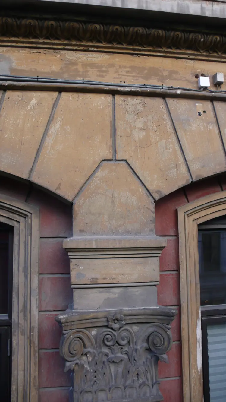 Søylemotiv med kapitél med volutter (snurrer) og akantusblader. Denne typen søyler (Joniske) forbindes gjerne med "den modne kvinnen" og er brukt på handelsbygninger og skoler (Universitetet i Oslo byggeår 1851). Foto: T. Berner