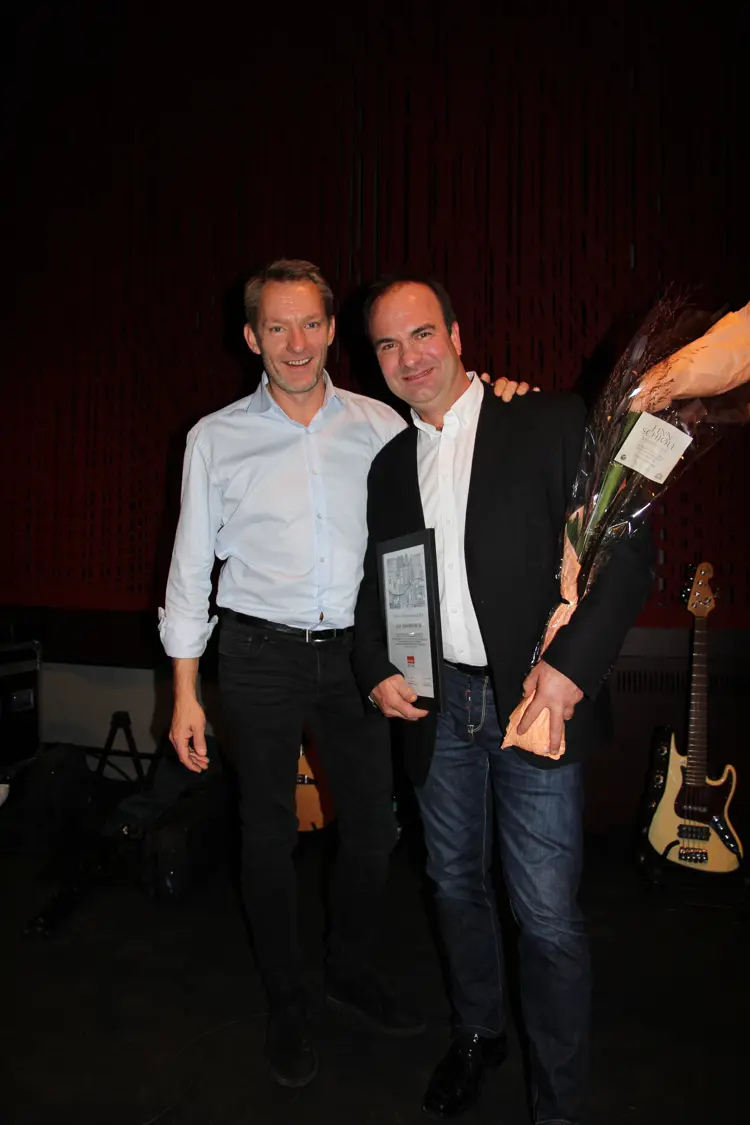 Espen Frisell og Jarle Kristiansen fra Olaf JOhansens eftf as med diplom og blomster. Bedriften har begått et meget godt arbeid blant annet med kobbertaket på "Sverreslottet" i Drammensveien 42. Foto: Bygg og Bevar