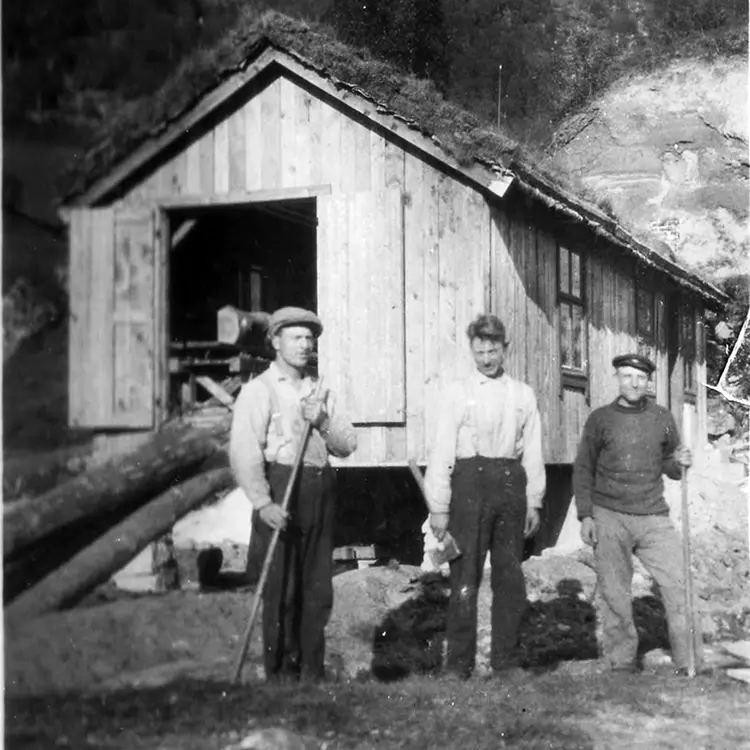 Den fyrste tømmersaga som brørne sette opp i Kvilsa, driven med vasshjul. Frå venstre: John, Jakob og Ole O. Mork (halvbror). Truleg frå 1926. Foto: Ukjent.