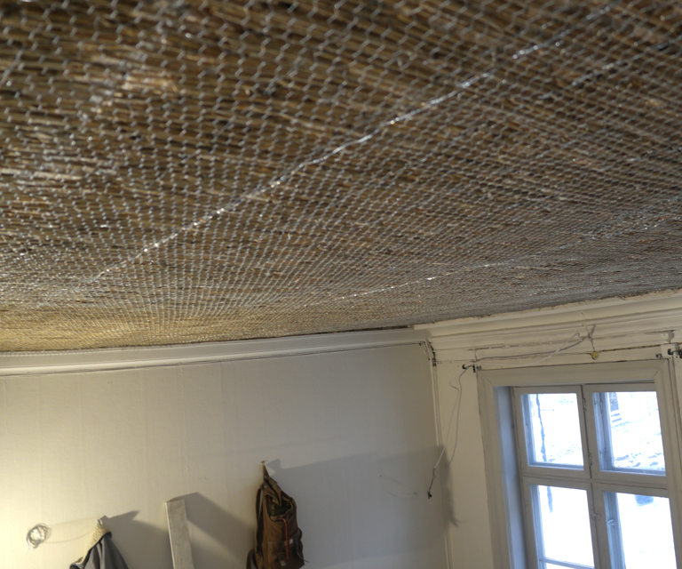 Hønsenettingen festes med kramper og hakespiker. Det er viktig at rørvev og hønsenetting er stramt og ikke svikter når det er festet. Men det må ikke strammes så mye at rutene ryker eller deformeres. Foto: HKHN