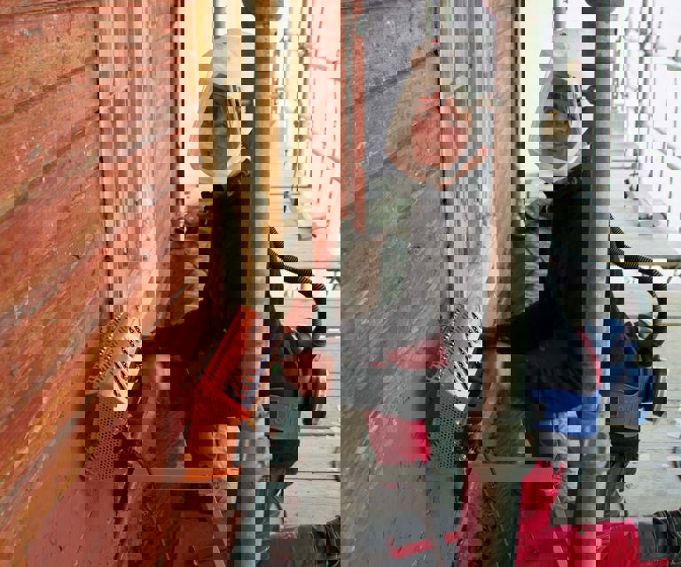 BESKYTTET: Trine Wanvik tar arbeidsmiljøet på alvor når hun fjerner blyholdig maling. Foto: Georg Mathisen, Maleren