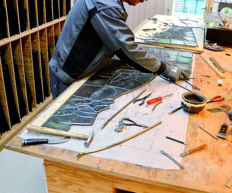 Restaureringstekniker Geir Lyshaug på verkstedet, her med et glassmaleri fra Holmestrand kirke, laget av Per Vigeland, sønn av Emanuel Vigeland. Foto: K. I Hovelsen