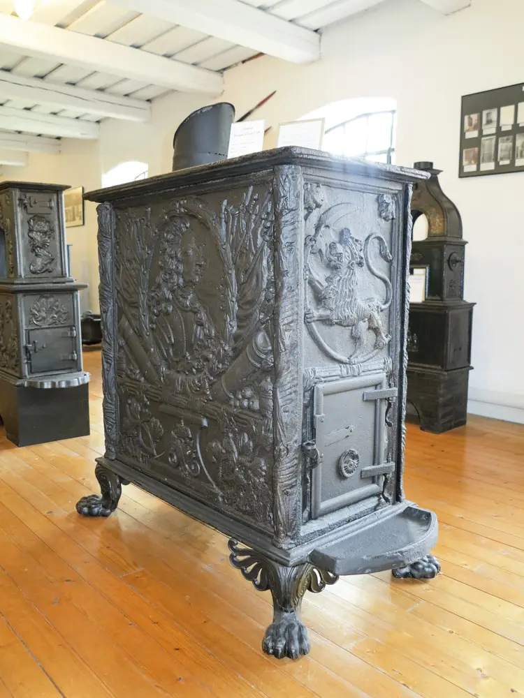 Fossum Verk 1739, barokk vindovn med motiv av Fredrik 4. i profil og riksløven på endeplaten. Ben og nyere dør fra 1800-tallet.