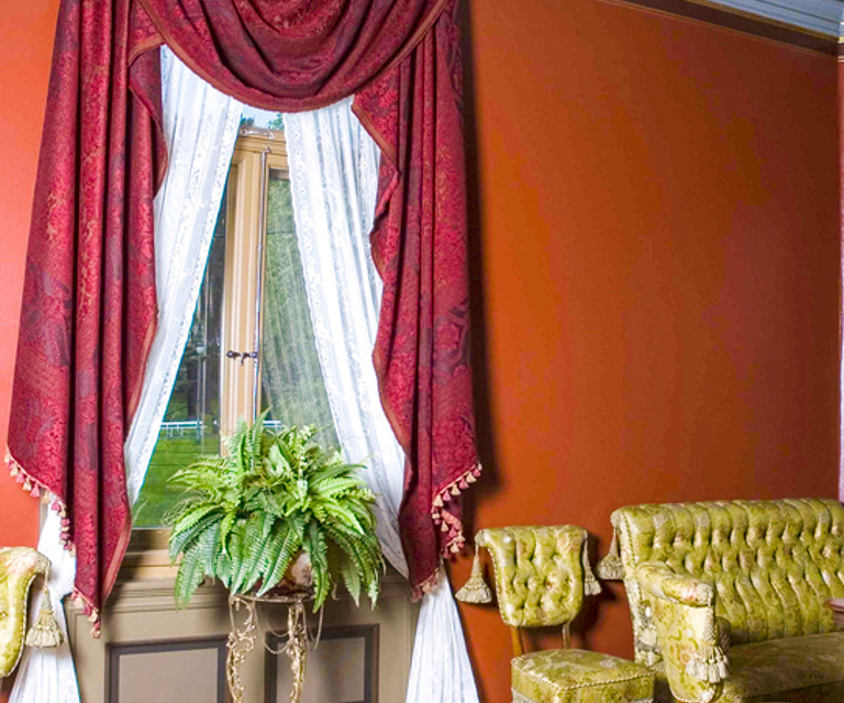 Gardiner fra «Den Røde Salong» i Ibsens leilighet i Arbins gate. Tidstypisk arrangement med hvite sidegardiner i kombinasjon med en kappe av tyngre stoff. Foto: Norsk Folkemuseum.