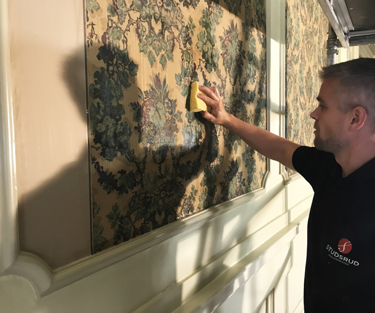 Malermester Roger Studsrud renser en tapet i Halden teater Foto Malermester Studsrud as