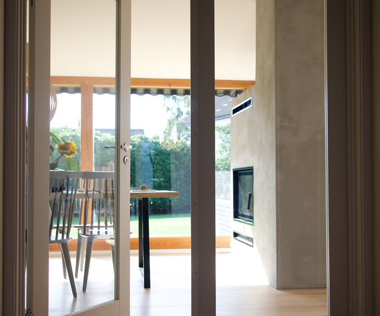 Fra stuen er det doble glassdører ut til en koselig uteplass, perfekt for hyggelige måltider og late sommerdager.