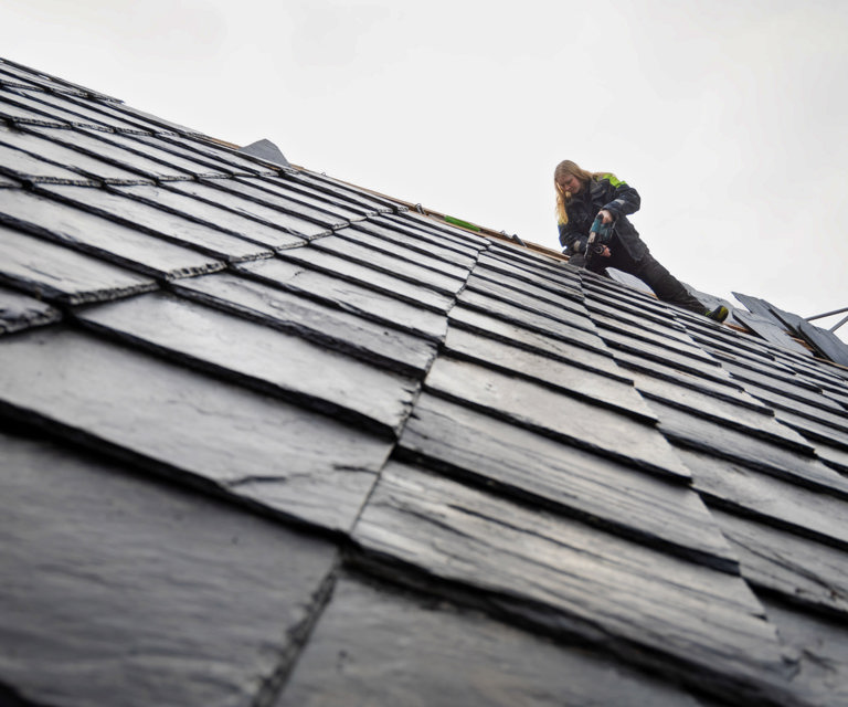 Skiferarbeid i høyden – Guro i arbeid på taket. Godt man ikke har høydeskrekk!