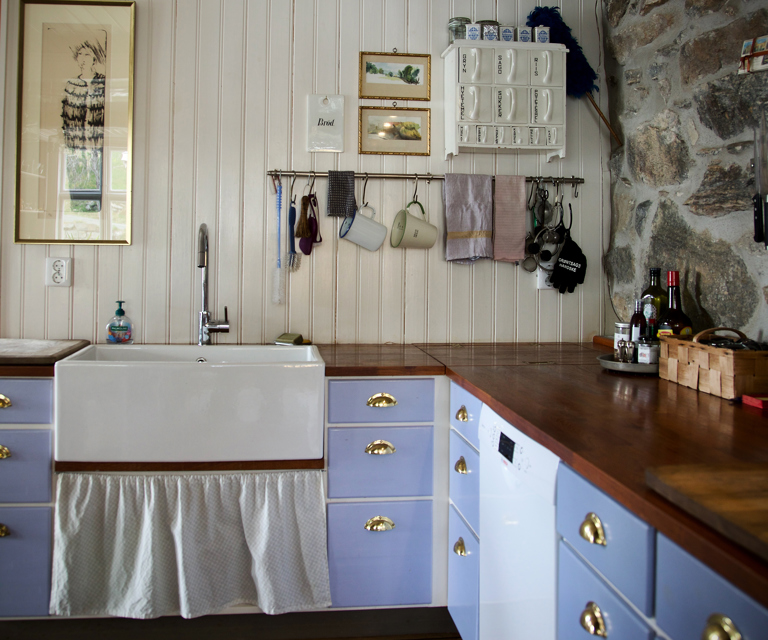 En vegg sto tidligere inntil en fjellvegg med rennende vann og var helt råtten av fukt. I dag står veggen åpen mot fjellet og er et blikkfang i kjøkkenet. Foto: Lise Bjelland