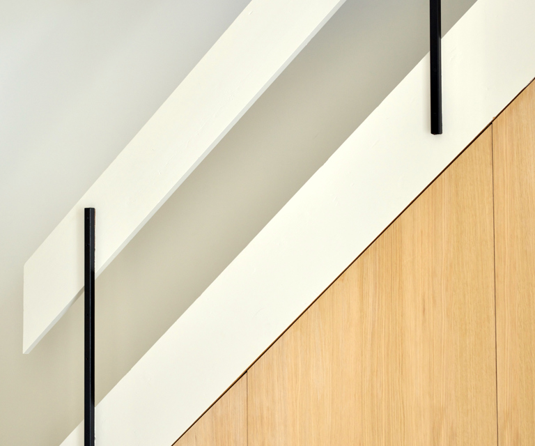 Den moderne trappeløsningen kombinerer treverk og sorte rekkverk, som gir en ren og stilfull overgang mellom etasjene. 